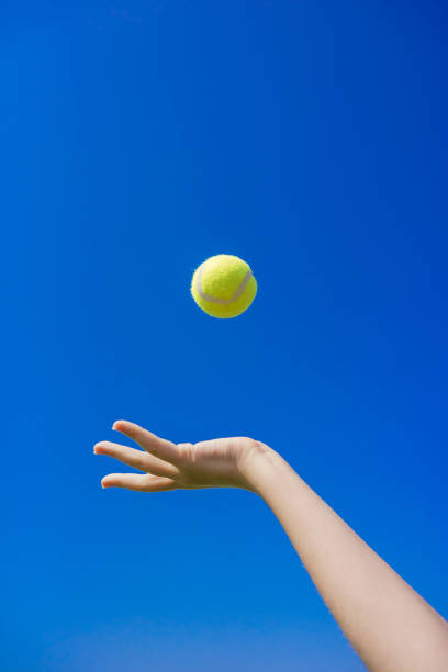 テニスボールを空に投げた手 - tennis ball ball isolated sport ストックフォトと画像