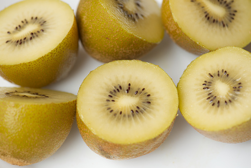 Kiwi peeled next to a cloth and a knife in close-up