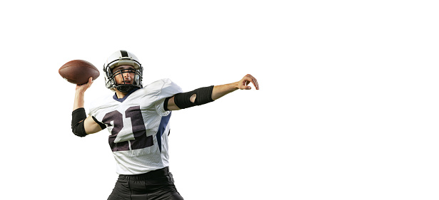 Portrait of young man, professional american football player training, throwing ball isolated over white background. Concept of active life, team game, energy, sport, competition. Copy space for ad