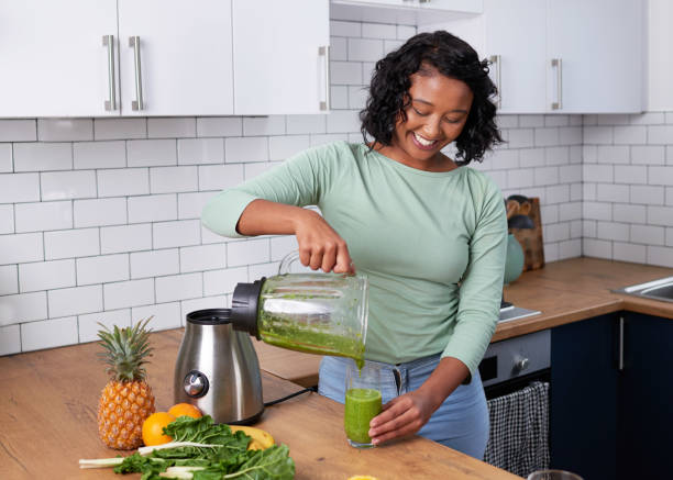 istock A young multi-ethnic woman pours a fresh green smoothie from blender in kitchen 1419300138