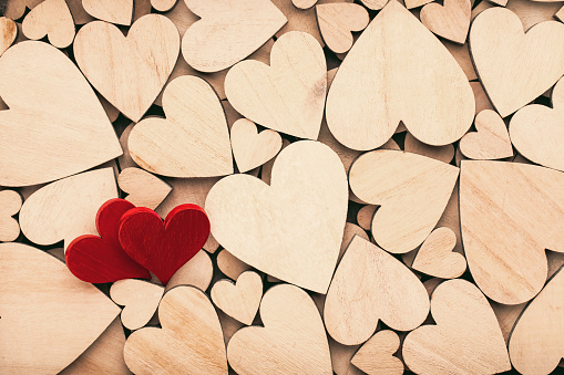 Wooden hearts, one red heart on the wooden heart background.