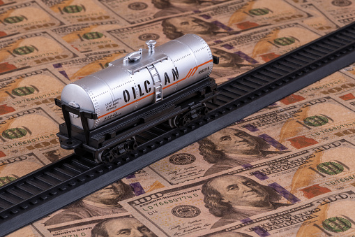 A toy tank for transporting petroleum products of the children's railroad stands on $ 100 bills