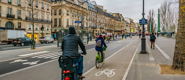 People riding bicycle at bikeway at historic center or paris, france