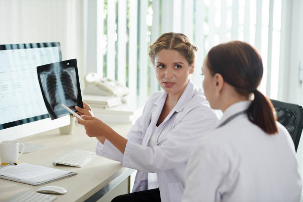 istock Doctor Showing Lungs X-ray to Patient 1419300671