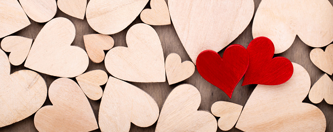 Wooden hearts, one red heart on the wooden heart background.