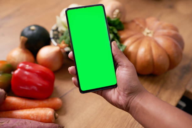 istock Close up of mobile phone screen with whole vegetables - chroma key 1419301191