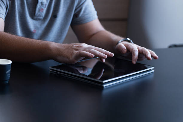 Close up of business man hands working on tablet\nBusiness man with vitiligo desease working in the office