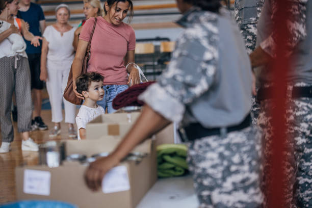 persone che ricevono donazioni dopo un disastro naturale - homelessness food in a row people foto e immagini stock