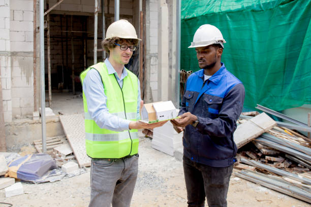 istock Architect and builder talking and holding model house at construction site, contractor and worker discussion and planning strategy about progress infrastructure of real estate, engineer concept. 1419309466
