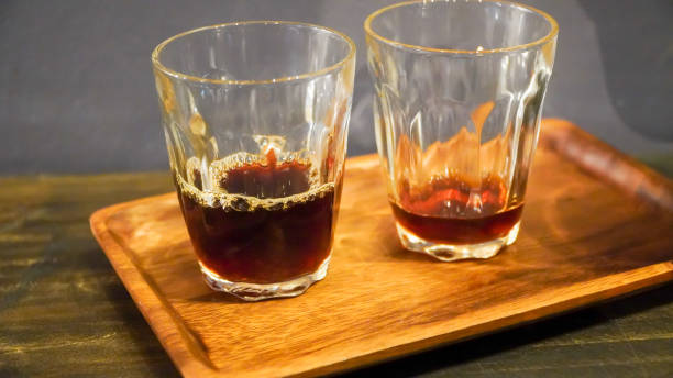 istock Two clear glass cups with leftover espresso on a dark wooden table. 1419311990
