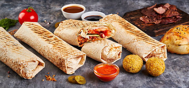 Eastern traditional shawarma with chicken and vegetables, Doner Kebab with sauces. Fast food. Eastern food.