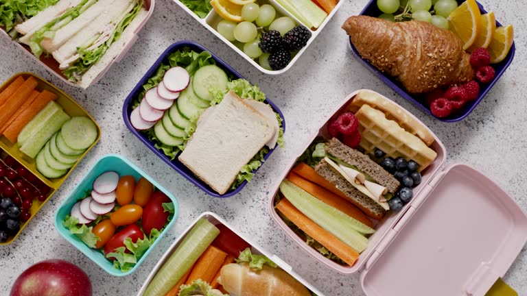 Shot of school lunchboxes with various healthy nutritious meals on stone background
