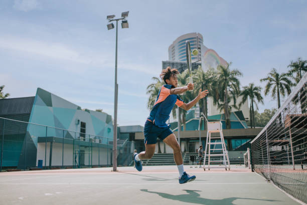 habile joueur de tennis asiatique chinois sautant dans les airs en faisant un arrêt - tennis asian ethnicity male forehand photos et images de collection