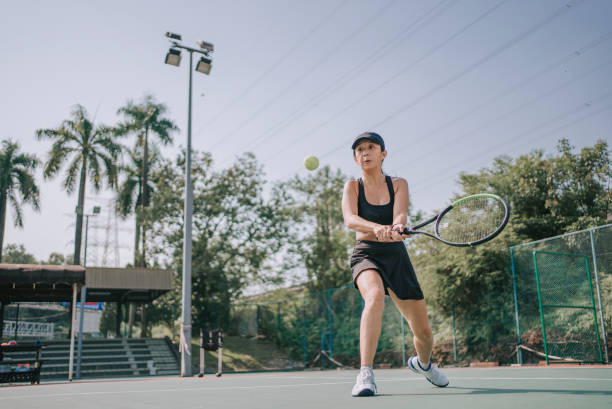 asiatische chinesische tennisspielerin, die am wochenendmorgen tennis im hartplatz lernt - forehand stock-fotos und bilder