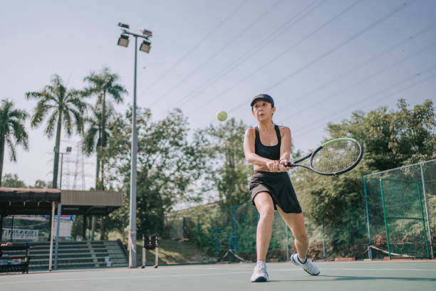 joueuse de tennis chinoise d’origine asiatique s’entraînant à apprendre le tennis sur surface dure le matin du week-end - forehand photos et images de collection