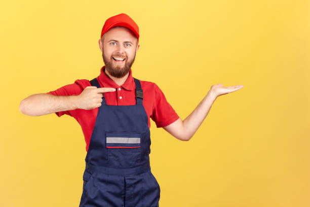 istock Worker man pointing finger aside, presenting copyspace on his palm, advertise his service. 1419317116