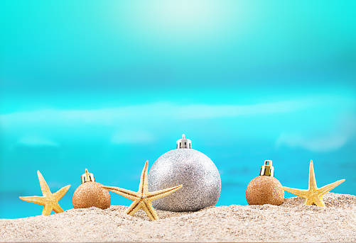 Starfish and Christmas tree shiny balls on beach. Sunny. Concept holiday and recreation, travel in hot countries. New Year. Copy space
