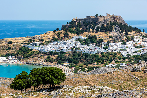 Rhodes Island, Greece - May 26, 2022: Panoramic view of Lindos bay, the village and the Akropolis of Lindos in Rhodes island, Greece.