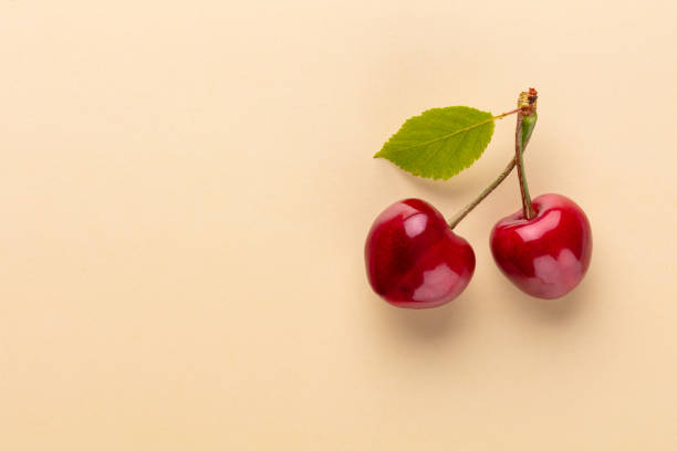 istock Cherry berries on a pastel background top view.  Background with a cherry on a sprig, flat lay 1419323258