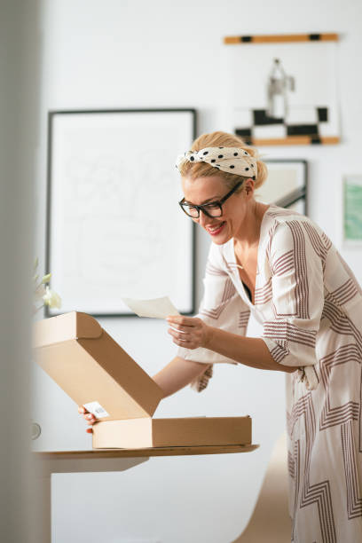 istock Beautiful Woman Happy While Reading a Note She Received With the Carton Box 1419325102