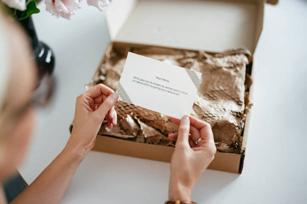 istock Anonymous Woman Holding a Paper Note She Received With a Gift Box 1419325770