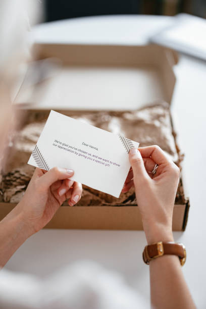 istock Anonymous Woman Holding a Paper Note She Received With a Gift Box 1419325786