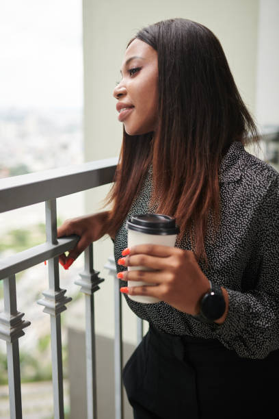 istock Businesswoman Drinking Coffee on Balcony 1419328779