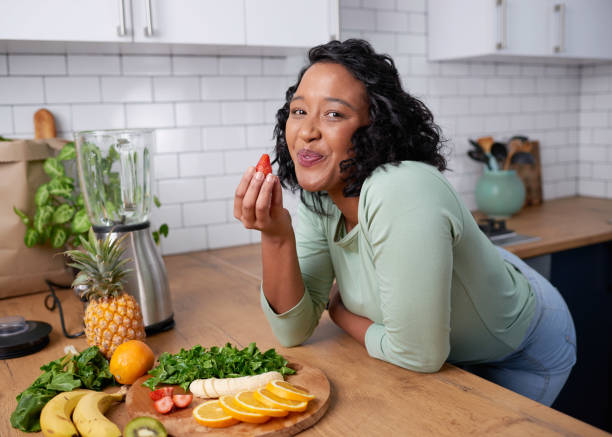 istock A young attractive woman tastes a strawberry while preparing fruit for smoothie 1419328899