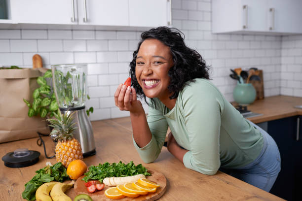 istock A young attractive woman tastes a strawberry while preparing fruit for smoothie 1419328921