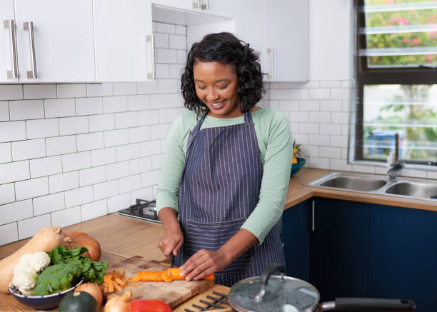 istock A young multiracial woman chops carrots for dinner in her kitchen 1419328924