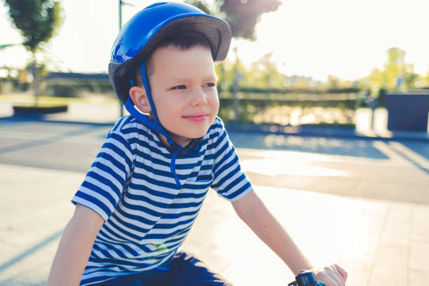 Little Kid Boy in Colorful Warm Clothes in Autumn Forest Park Driving Bicycle. Active Child Cycling on Sunny Fall Day in Nature. Safety, Sports, Leisure with Kids Concept. Casual Fashion for Children.