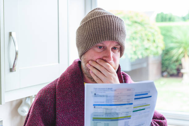 istock Cold and worried man checking bills at home 1419332375
