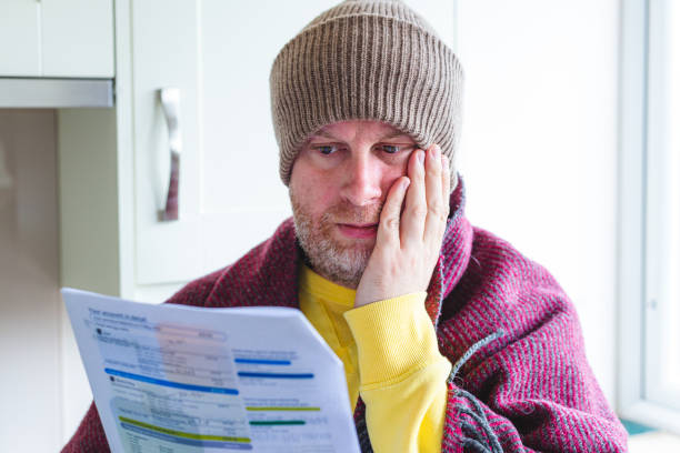 istock Cold and worried man checking bills at home 1419332419