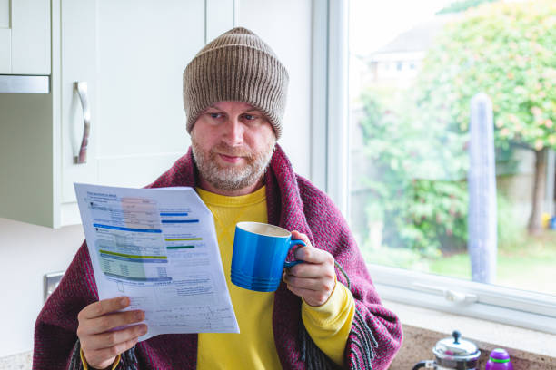 istock Cold and worried man checking bills at home 1419332511