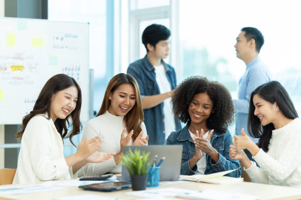 istock Business people showing team work while working in board room in office interior. People helping one of their colleague to finish new business plan. Business concept. Team work. 1419337505