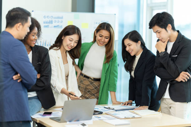 istock Business people showing team work while working in board room in office interior. People helping one of their colleague to finish new business plan. Business concept. Team work. 1419338069