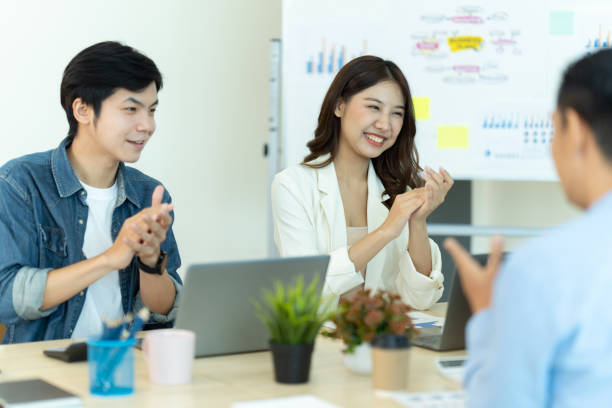 istock Business people showing team work while working in board room in office interior. People helping one of their colleague to finish new business plan. Business concept. Team work. 1419338141