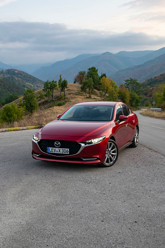 Montana, Bulgaria - 25th September, 2019: Mazda3 Sedan stopped on a road in mountain scenery. The fourth generation of Mazda3 was debut in 2018. This model is one of the most popular Mazda cars in the world.