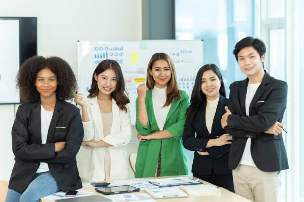 istock Business people showing team work while working in board room in office interior. People helping one of their colleague to finish new business plan. Business concept. Team work. 1419339908