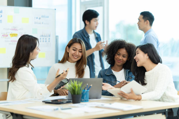 istock Business people showing team work while working in board room in office interior. People helping one of their colleague to finish new business plan. Business concept. Team work. 1419341630