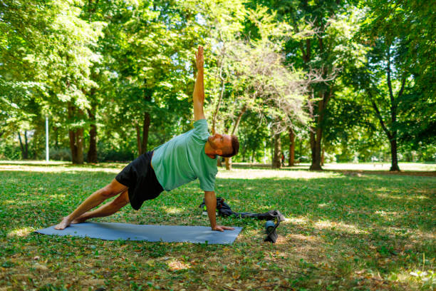 istock Man PracticingYoga In The Park, Utthita Parsvakonasana Pose 1419341647