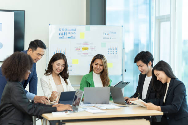 istock Business people showing team work while working in board room in office interior. People helping one of their colleague to finish new business plan. Business concept. Team work. 1419341775