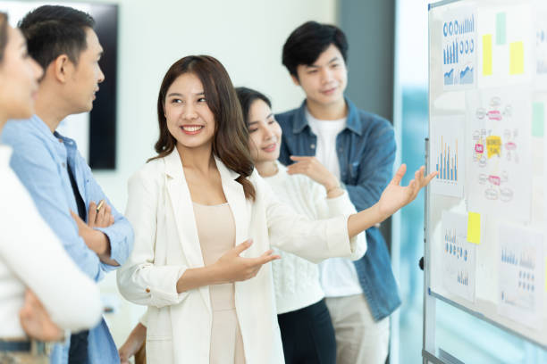 istock Business people showing team work while working in board room in office interior. People helping one of their colleague to finish new business plan. Business concept. Team work. 1419342012