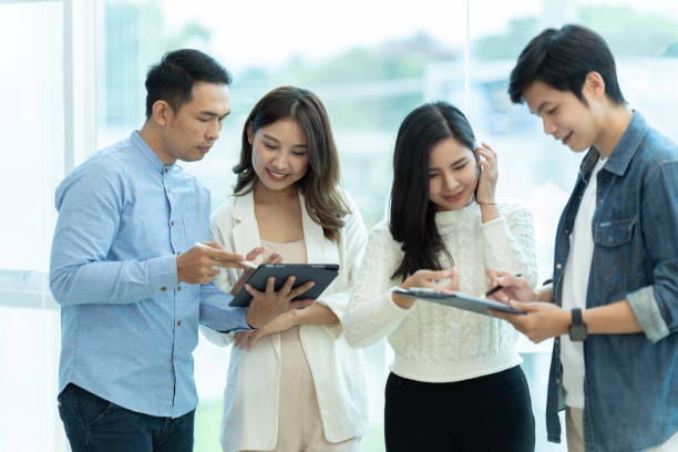 istock Business people showing team work while working in board room in office interior. People helping one of their colleague to finish new business plan. Business concept. Team work. 1419343004
