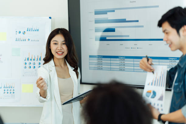 istock Business people showing team work while working in board room in office interior. People helping one of their colleague to finish new business plan. Business concept. Team work. 1419343314