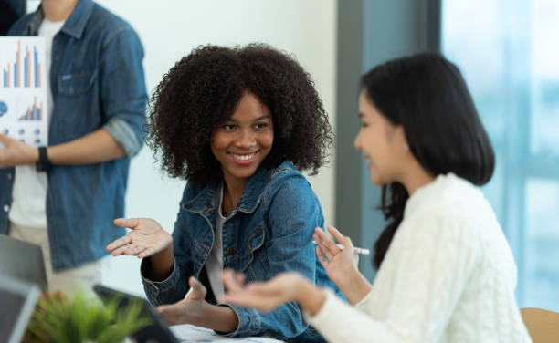 istock Business people showing team work while working in board room in office interior. People helping one of their colleague to finish new business plan. Business concept. Team work. 1419344837