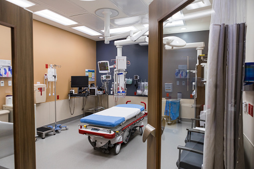 A view looking through the open door of a quiet, empty intensive care room in a modern hospital that is ready for the next patient.