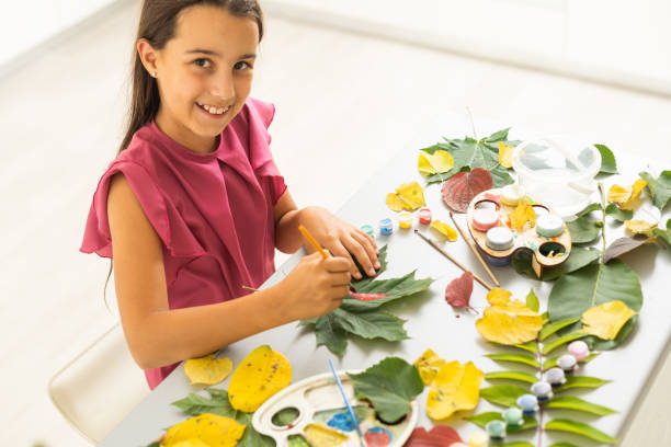 istock female hands paint autumn leaves on canvas with paints outdoor 1419348607