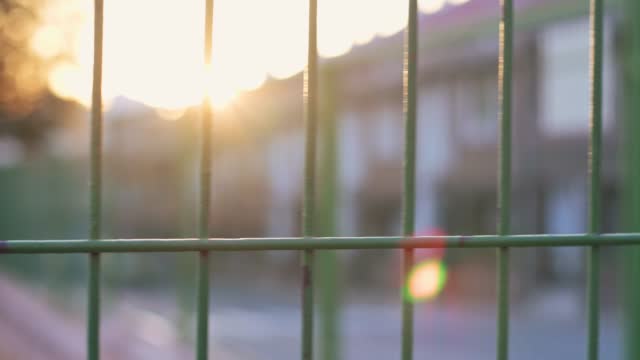 A school fence with the sunset in the background