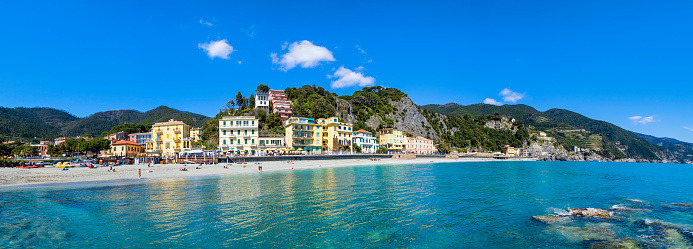 People enjoying a warm sunny spring day on the Beach of Fegina in Monterosso al Mare, one of the villages in the Cinque Terre (6 shots stitched)